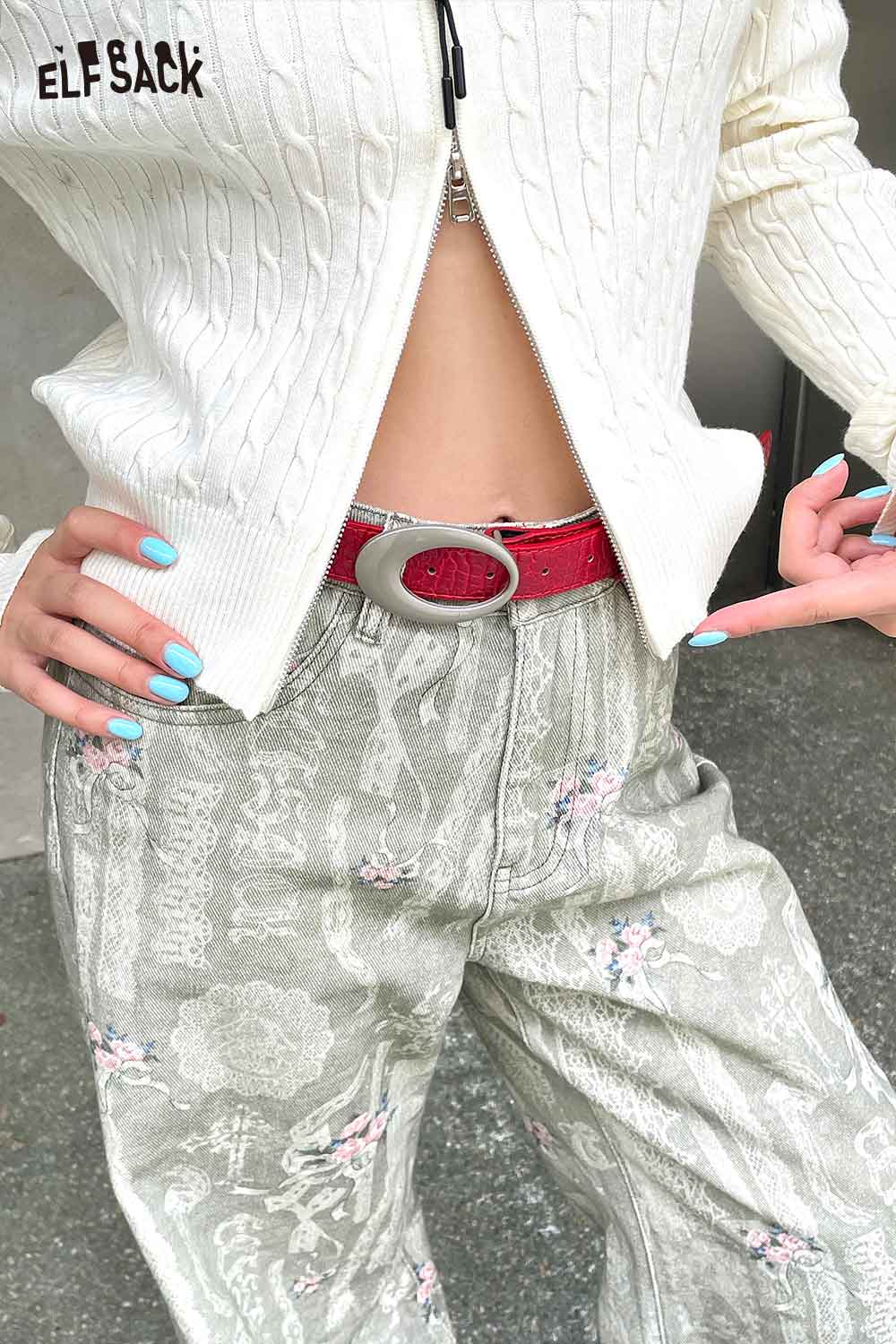 Vegan leather croc-embossed belt in red, styled with patterned pants and a cozy white sweater