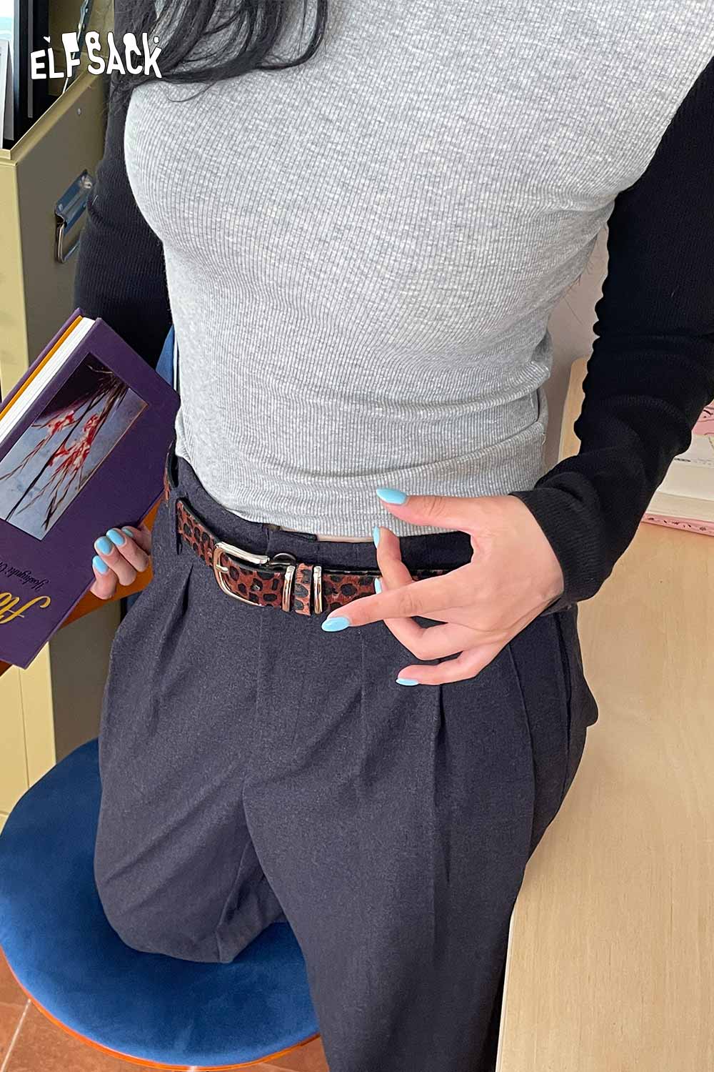Vegan suede animal print belt styled over gray top and high-waisted trousers for a trendy look