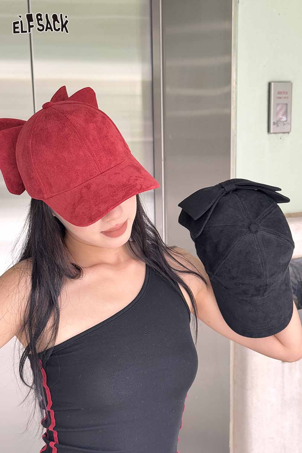 ELFSACK velour bow baseball cap in red with matching black cap showcased by model