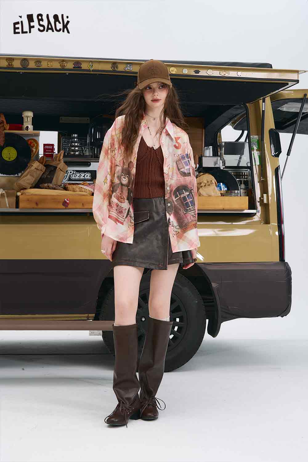 ELFSACK model wearing an all over print long sleeve shirt with brown knit top leather mini skirt and knee high boots