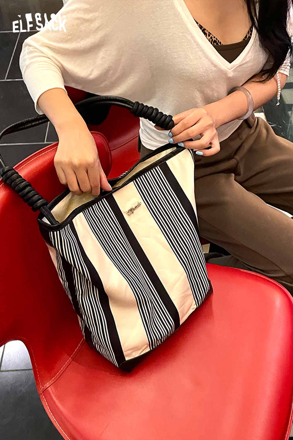 ELFSACK contrast stripe canvas tote bag held by a person on a red chair for a stylish look