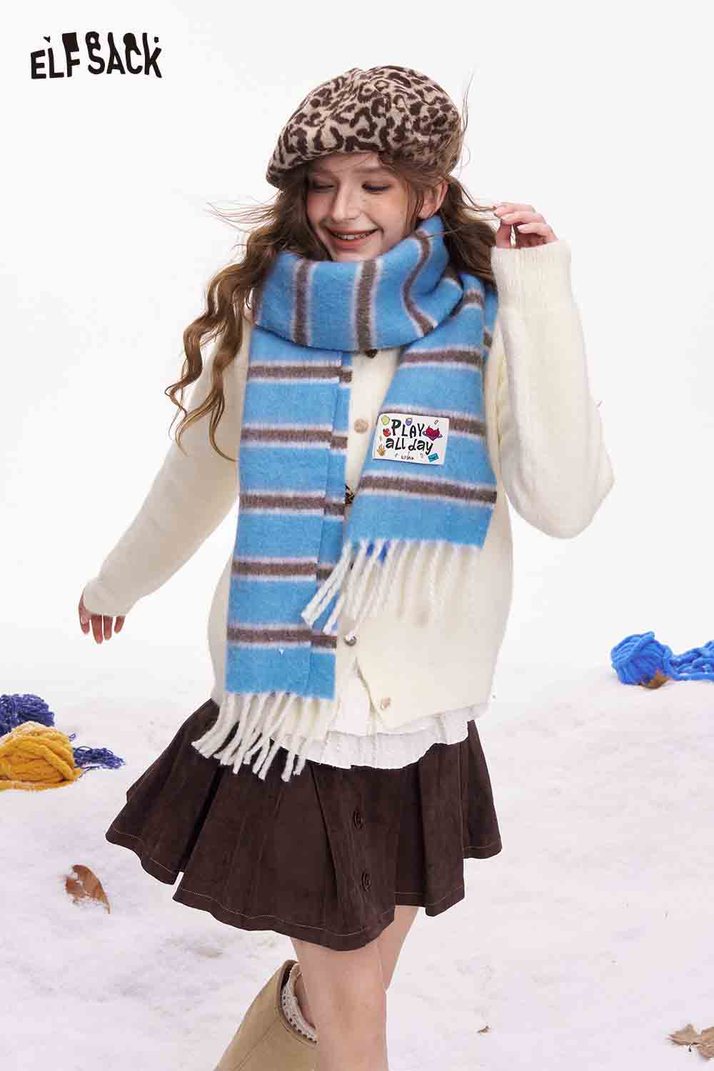 ELFSACK preppy striped fringe scarf in blue and brown, styled with a cozy sweater and skirt