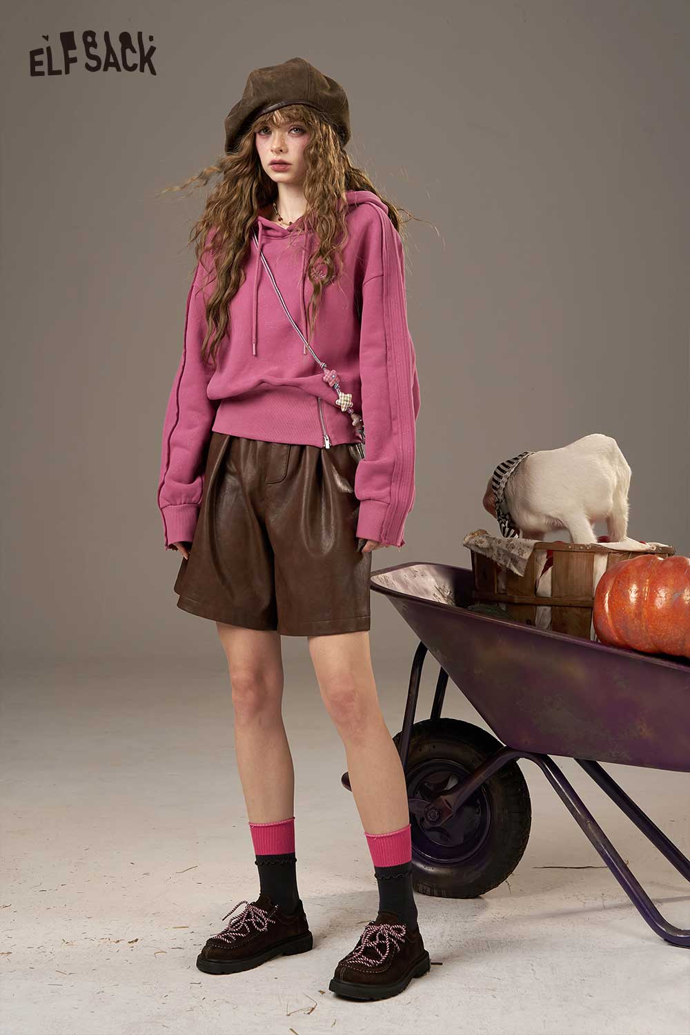 ELFSACK soft cropped hoodie for women in pink paired with brown leather shorts and accessories for a trendy look