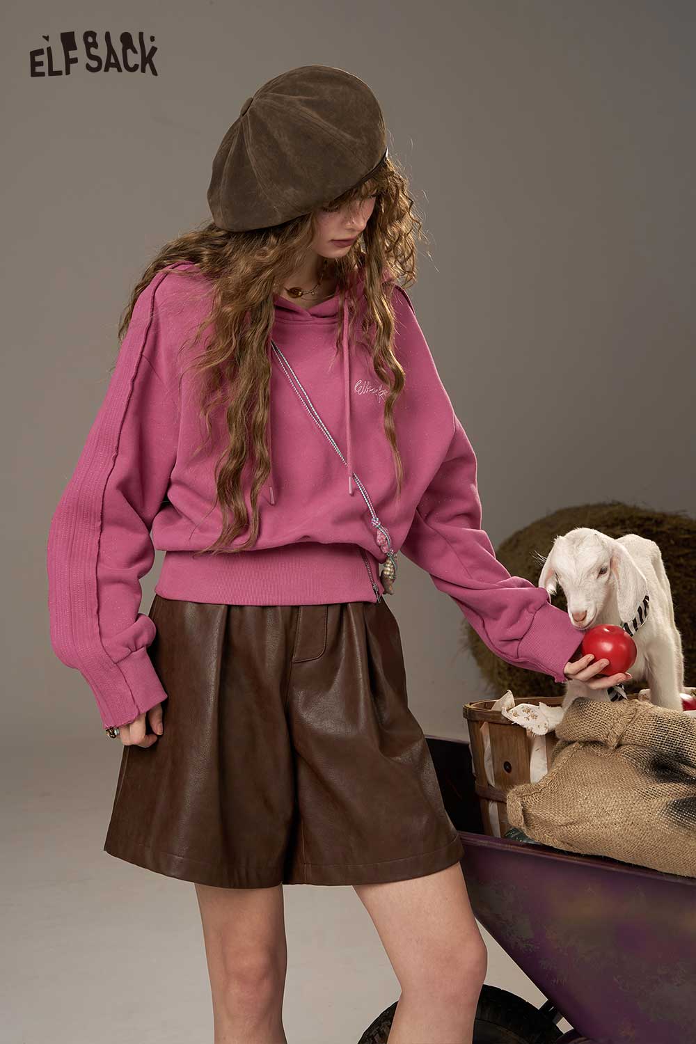 ELFSACK soft cropped hoodie for women in pink with relaxed fit and stylish design, paired with brown leather shorts