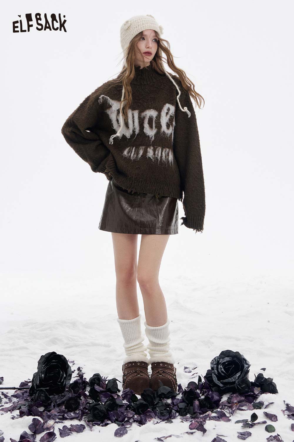 Model wearing a soft shiny leather skirt styled with a cozy sweater and knee-high socks