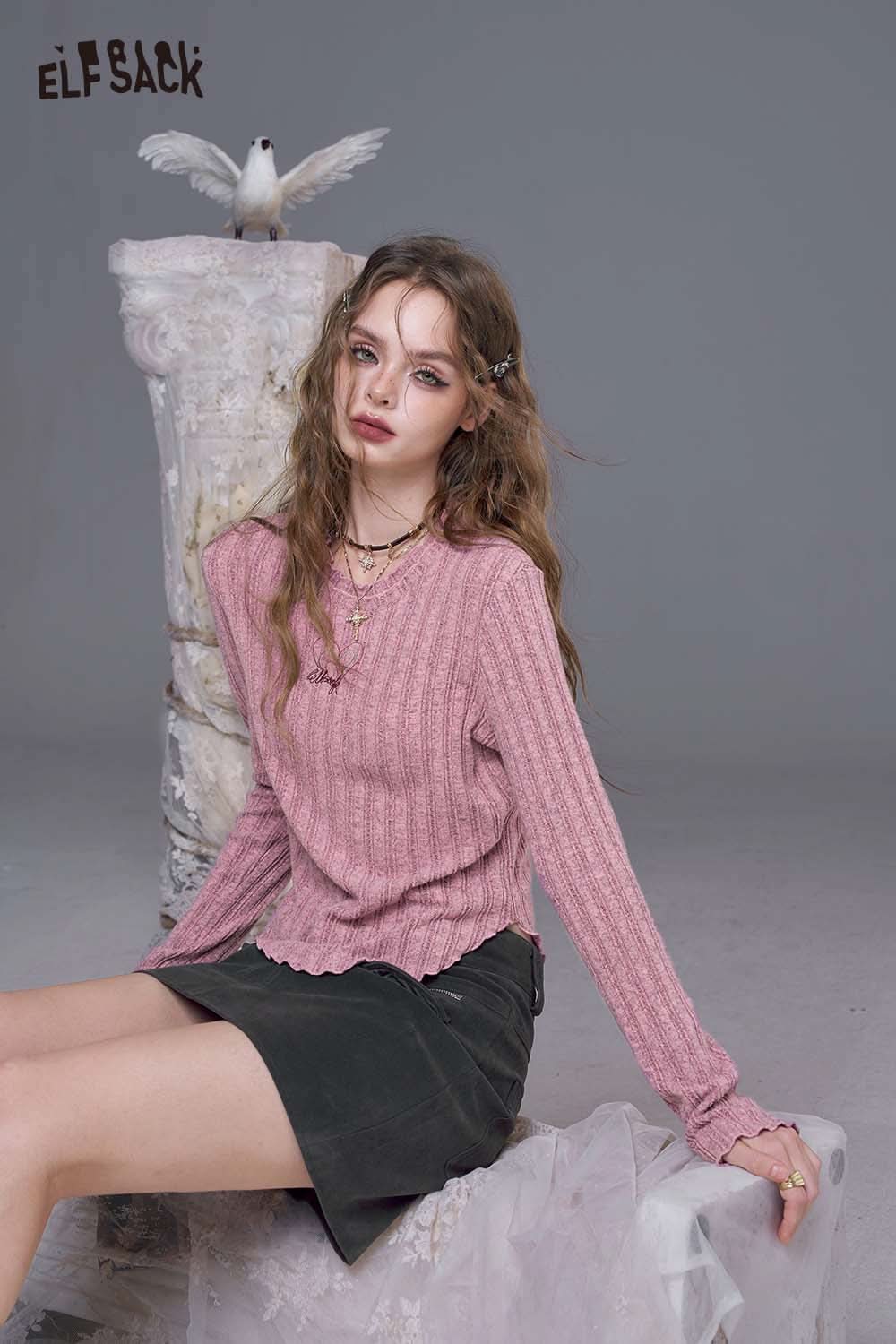 ELFSACK women's stretch knit top in pink, featuring a ribbed texture and a scalloped hem, styled with a skirt.