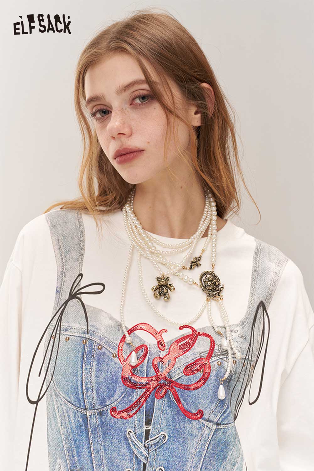 Woman wearing a vintage gothic pearl necklace layered over a stylish top from ELFSACK