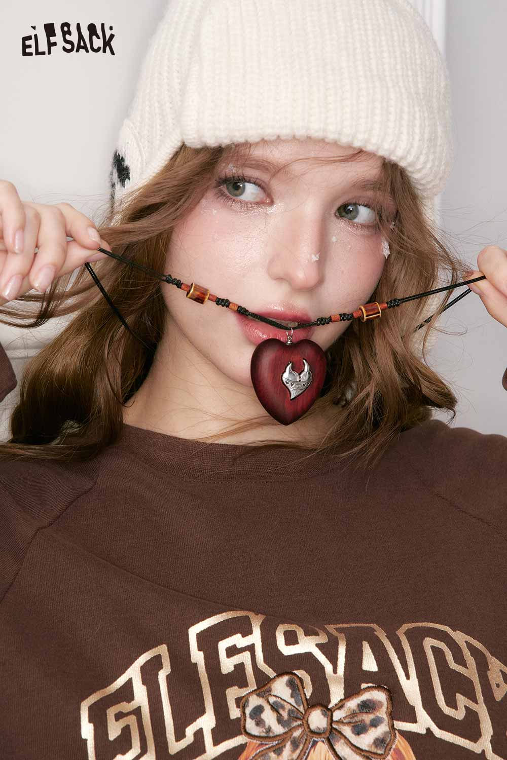 ELFSACK vintage heart pendant necklace showcased by a model wearing a cozy sweater and hat
