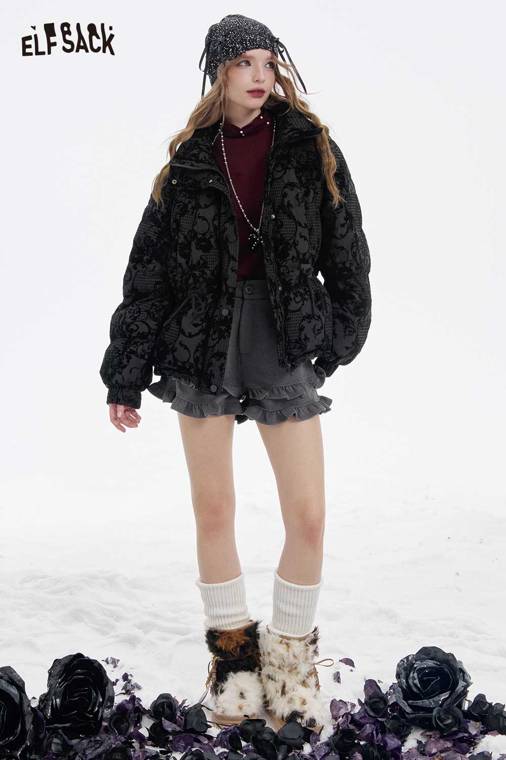 Model wearing a vintage jacquard puffy down coat from ELFSACK with stylish accessories in a snowy setting