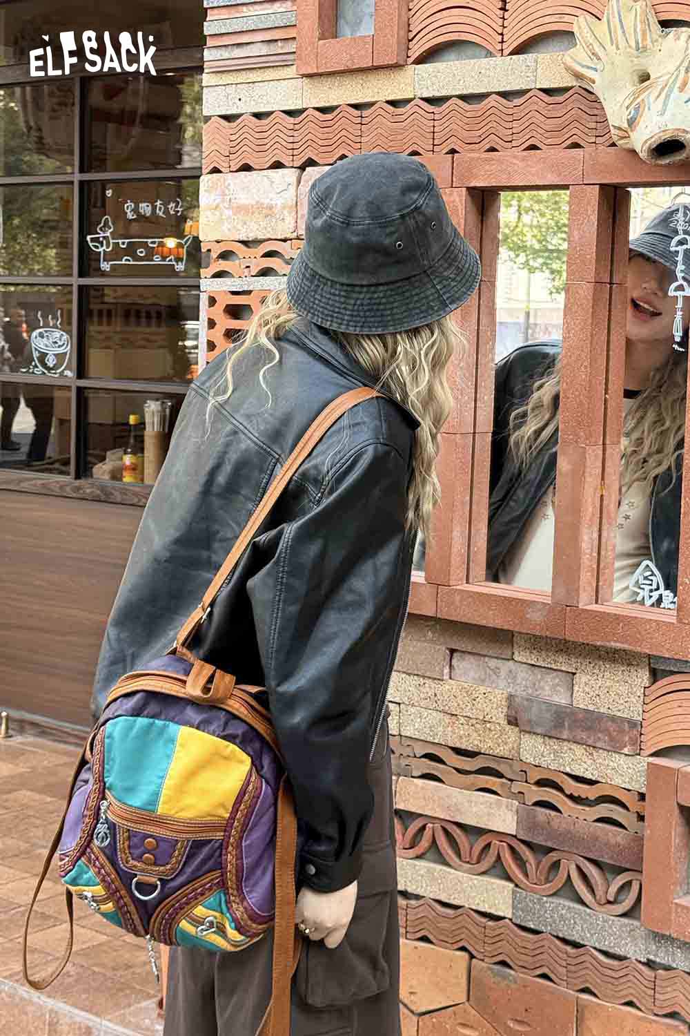 ELFSACK vintage patchwork leather backpack featured on a model wearing a black bucket hat and leather jacket