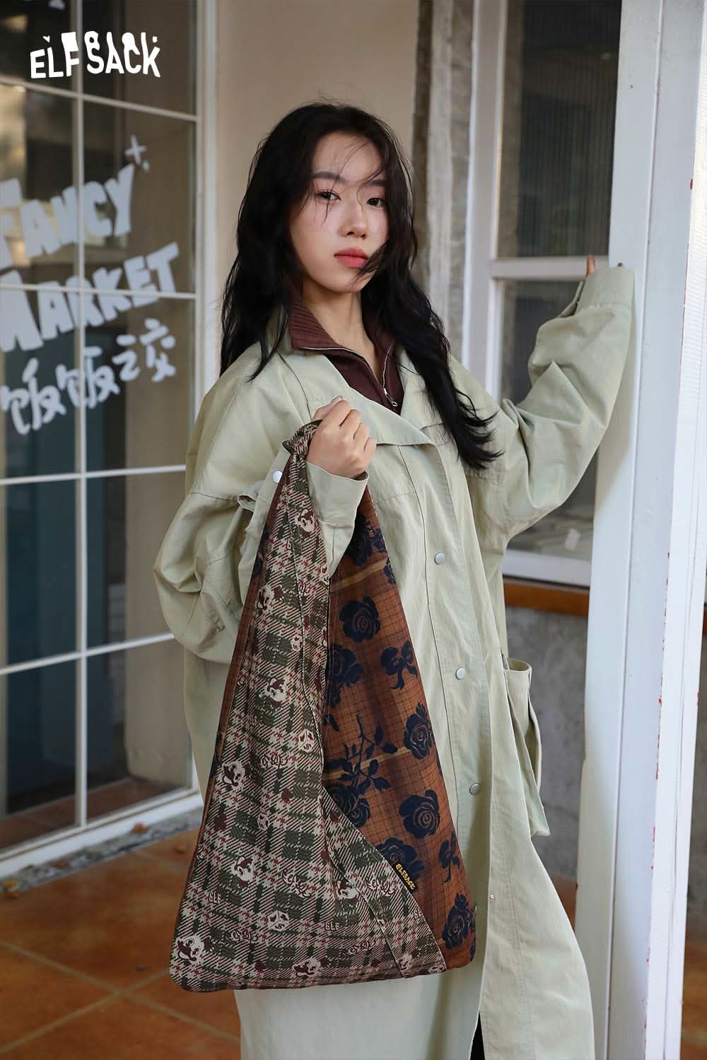 Model holding a vintage stripe tote bag from ELFSACK in a stylish urban setting