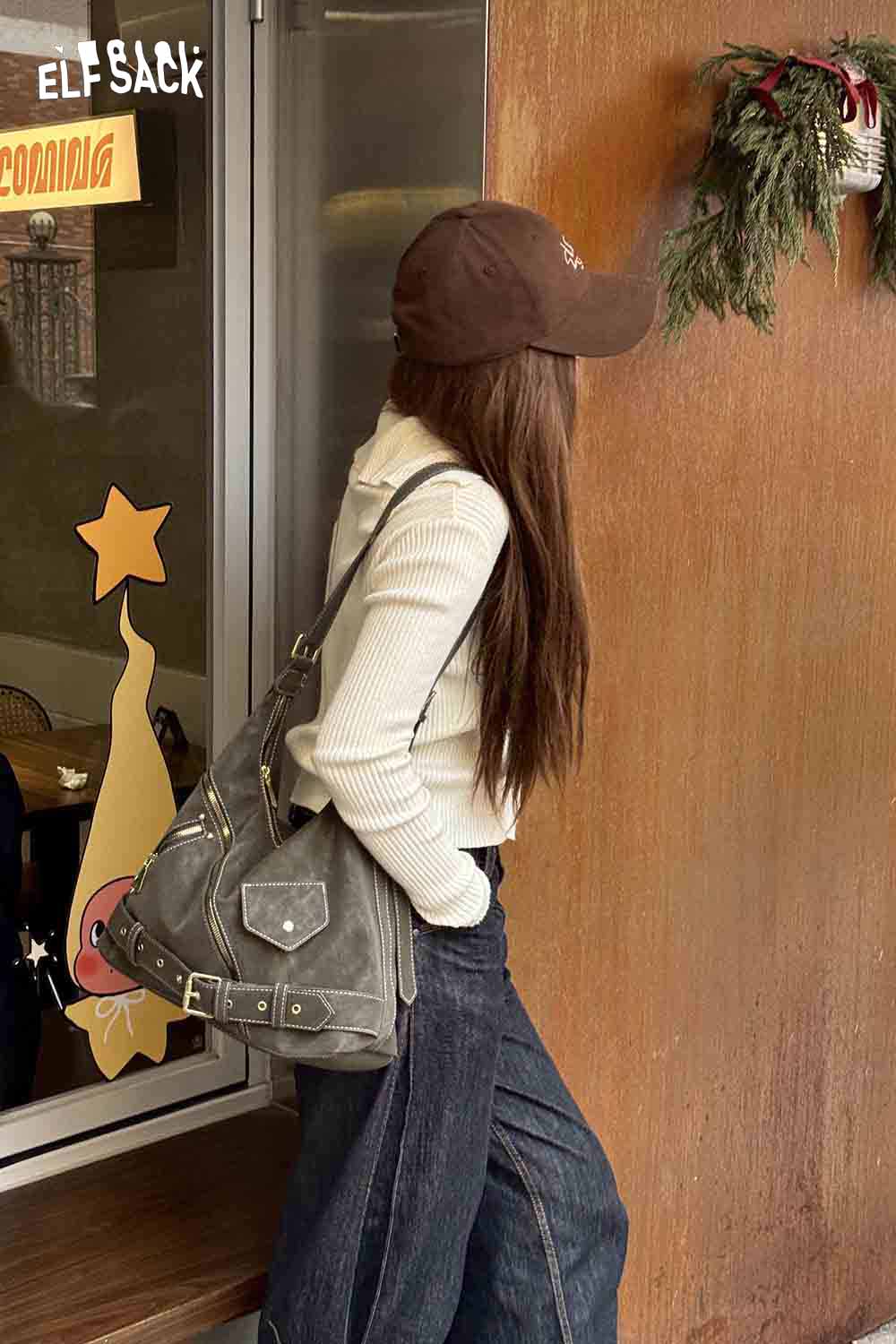 Stylish model wearing a vintage suede shoulder bag with casual outfit and cap