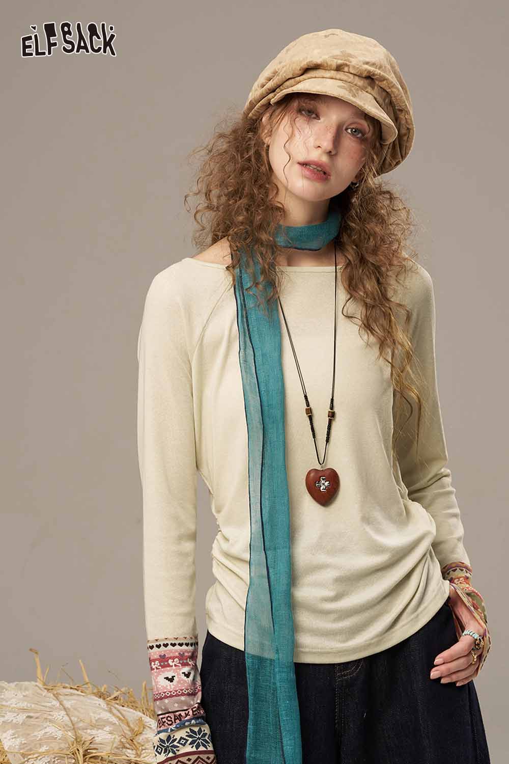 ELFSACK waist cinching long sleeve shirt in cream with colorful patterned sleeves and stylish accessories