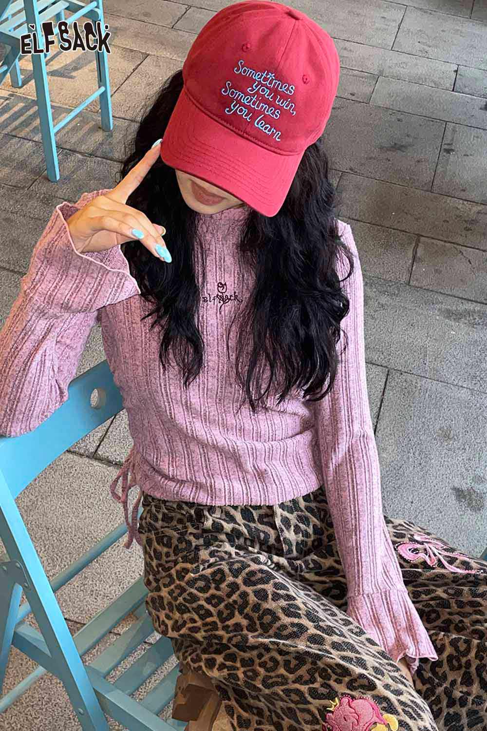 Stylish woman wearing a women's embroidered baseball cap with a pink sweater and leopard print pants