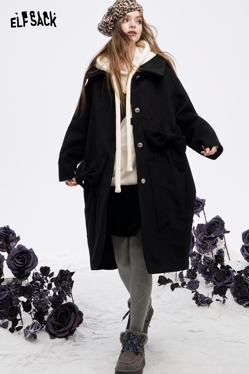 Model wearing a stylish women's casual graphic hoodie layered under a black coat for a trendy look