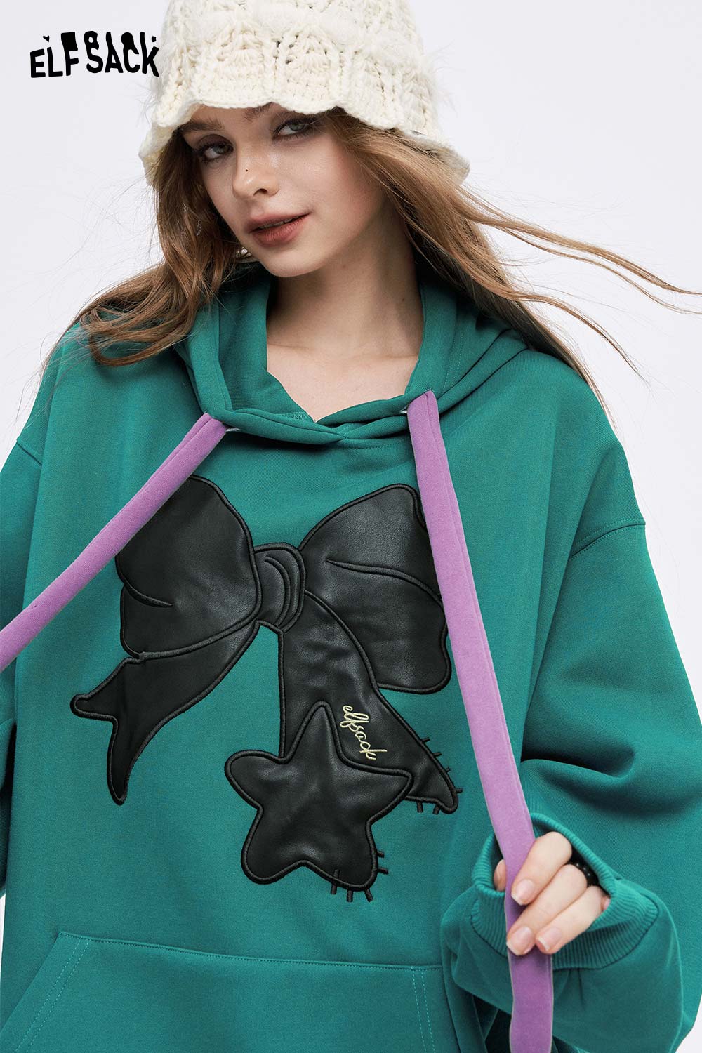 ELFSACK women's casual graphic hoodie in teal with a large bow design and purple drawstrings