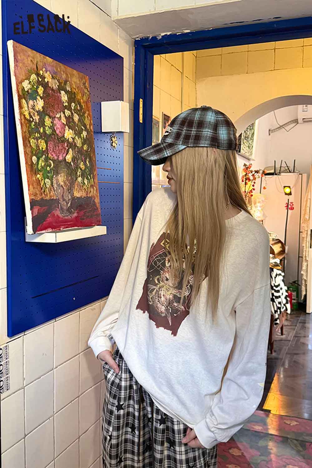 Fashionable women's checkered baseball cap styled with a casual outfit in a colorful boutique