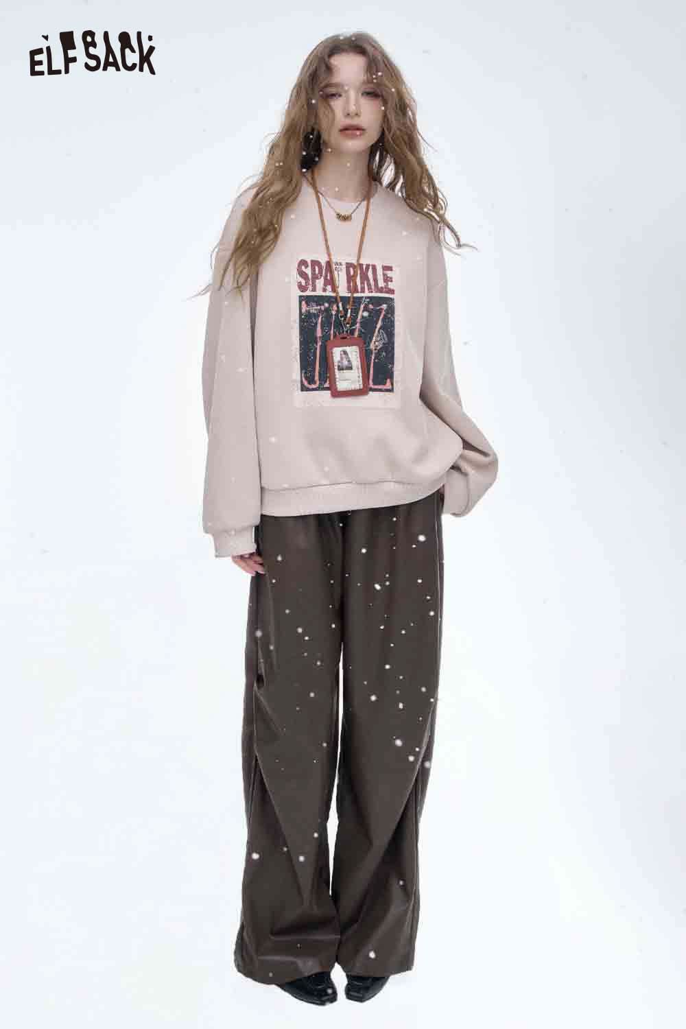 Women's faux leather straight leg pants in dark brown paired with a stylish graphic sweatshirt