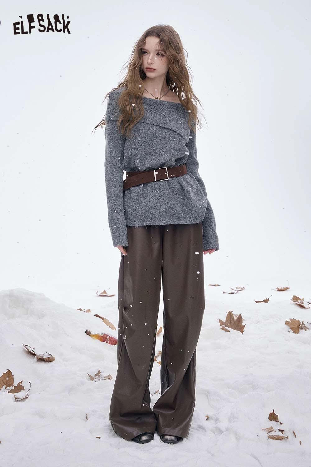 Model wearing women's faux leather straight leg pants paired with a stylish gray sweater and belt