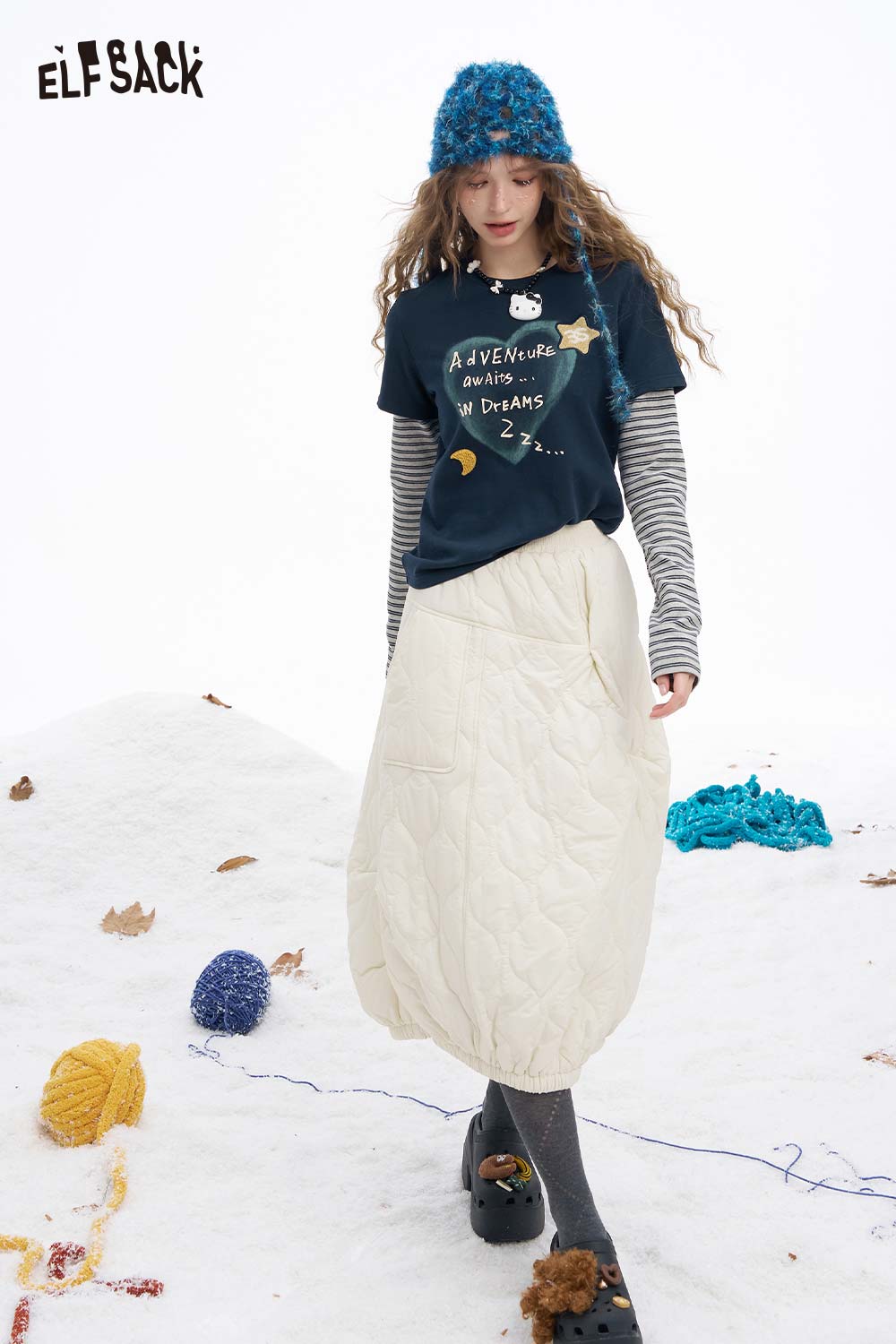 ELFSACK women's graphic embroidered long sleeve tshirt paired with a cozy quilted skirt in a snowy setting