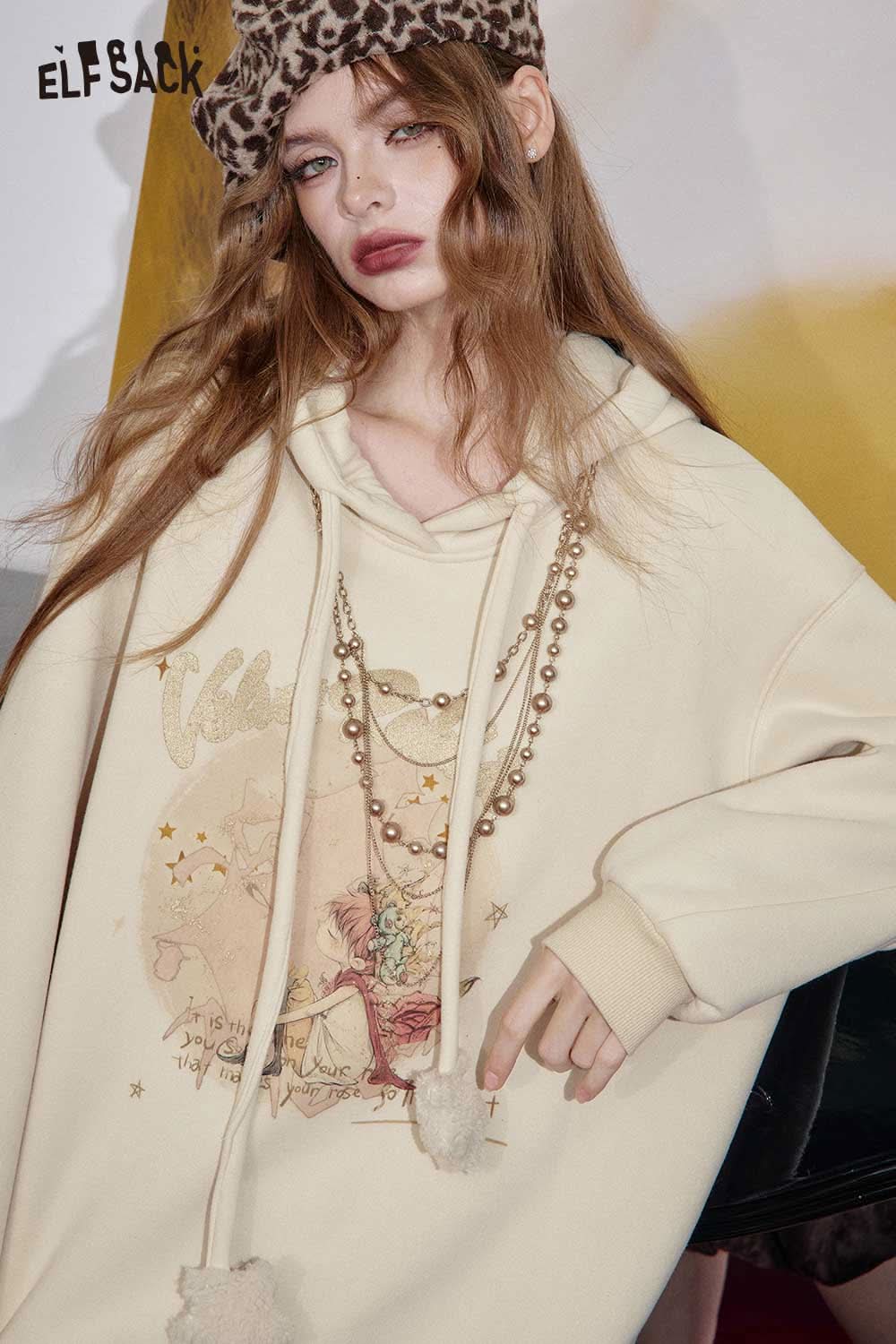 ELFSACK women's graphic print hoodie in cream with playful illustration and stylish pearl necklace