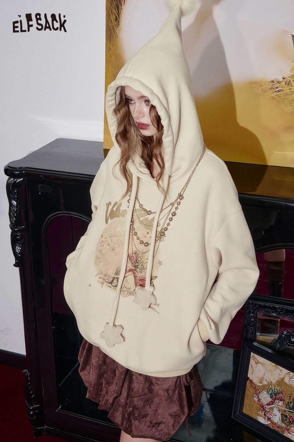 ELFSACK women's graphic print hoodie with a large hood and decorative charms for a trendy look