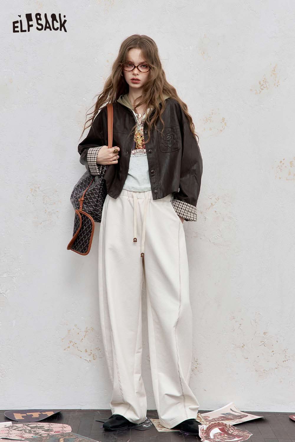 Fashionable woman in ELFSACK women's graphic print hoodie paired with oversized trousers and accessories