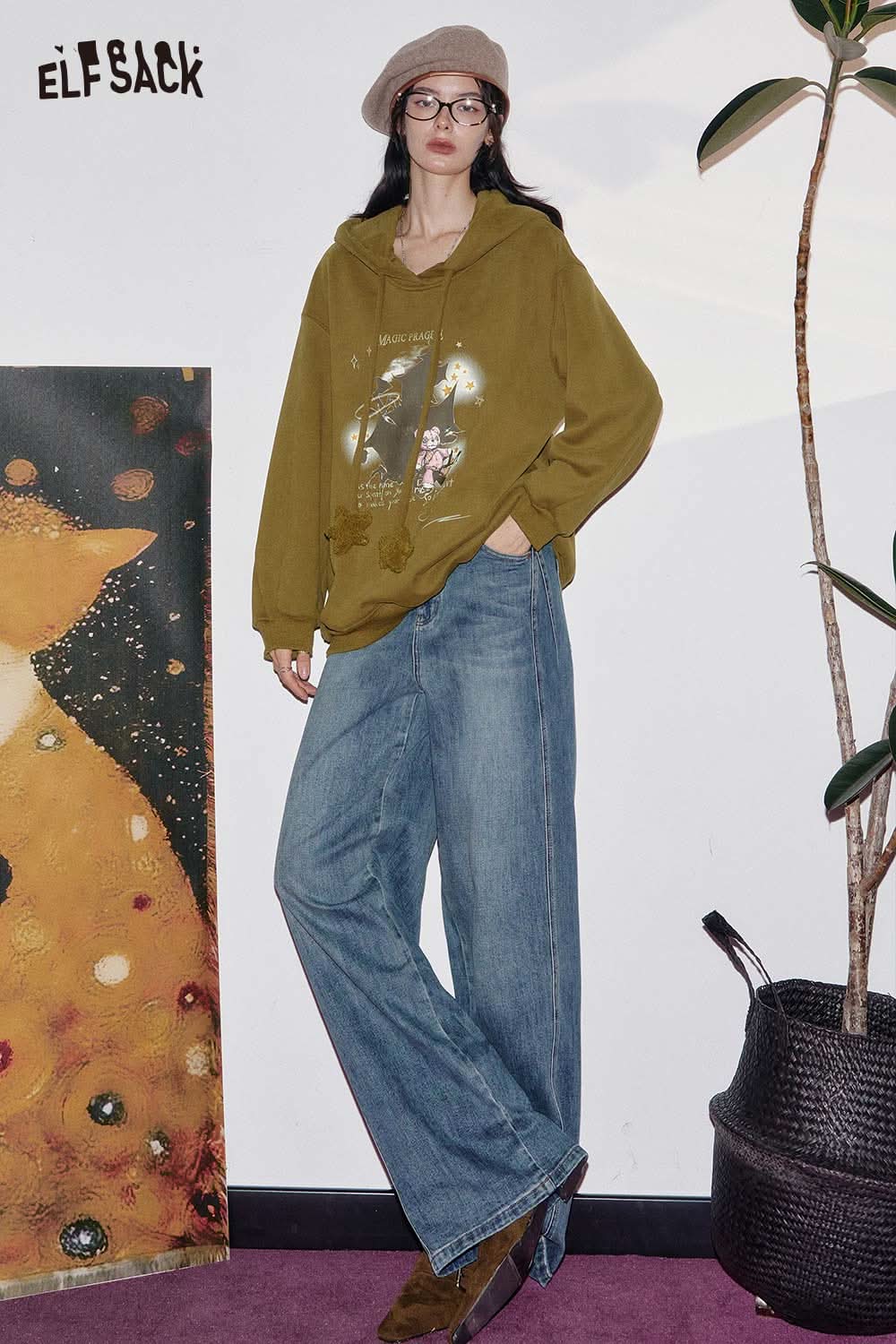 ELFSACK women's graphic print hoodie in olive green, styled with wide-leg jeans for a trendy look.