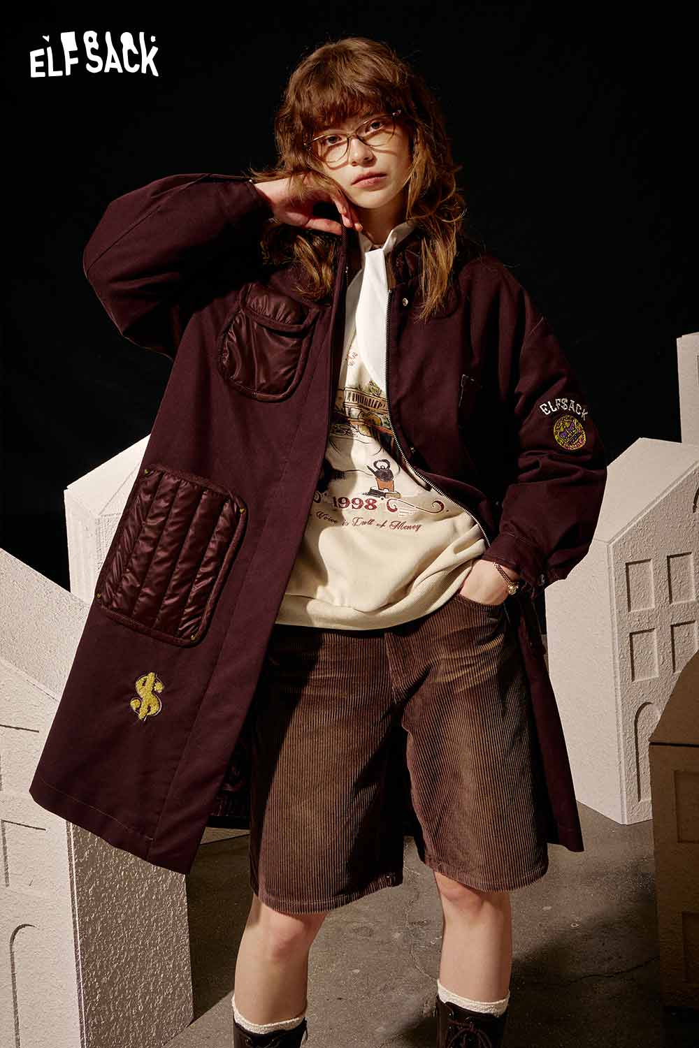 ELFSACK women's graphic sweatshirt layered under a stylish oversized coat for a chic urban look