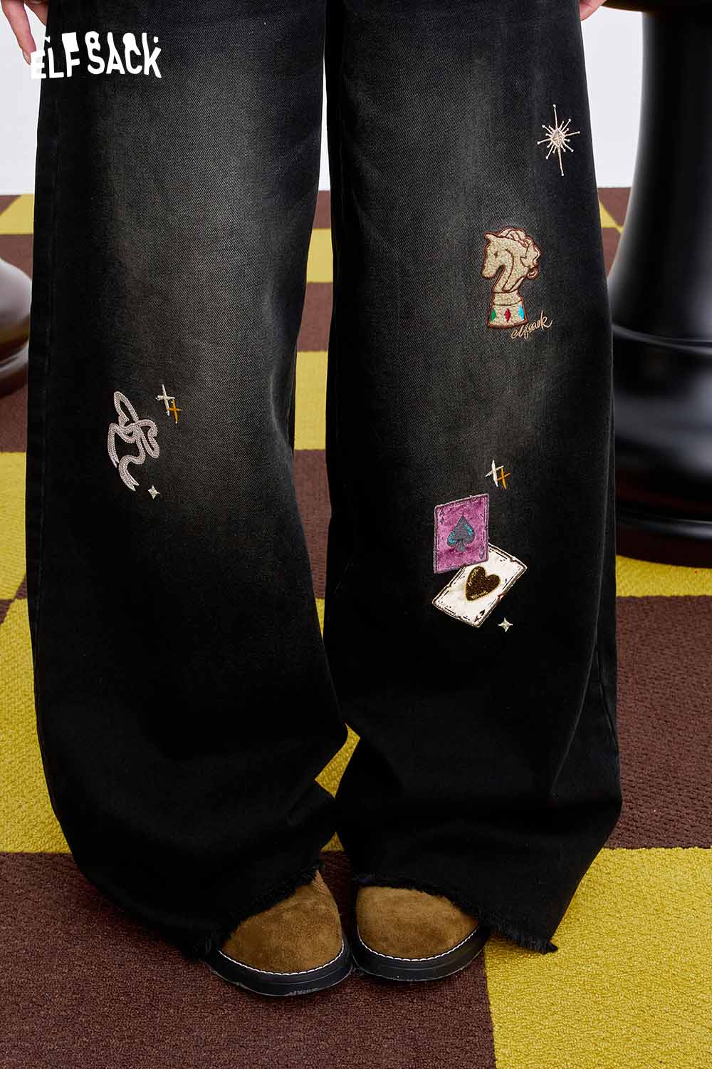 ELFSACK women's graphic wide leg pants featuring unique embroidered designs on a black fabric