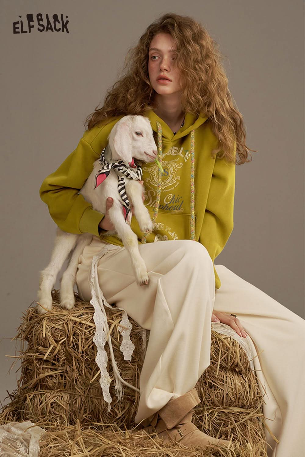 ELFSACK women's oversized print hoodie in olive green, styled with a model holding a goat