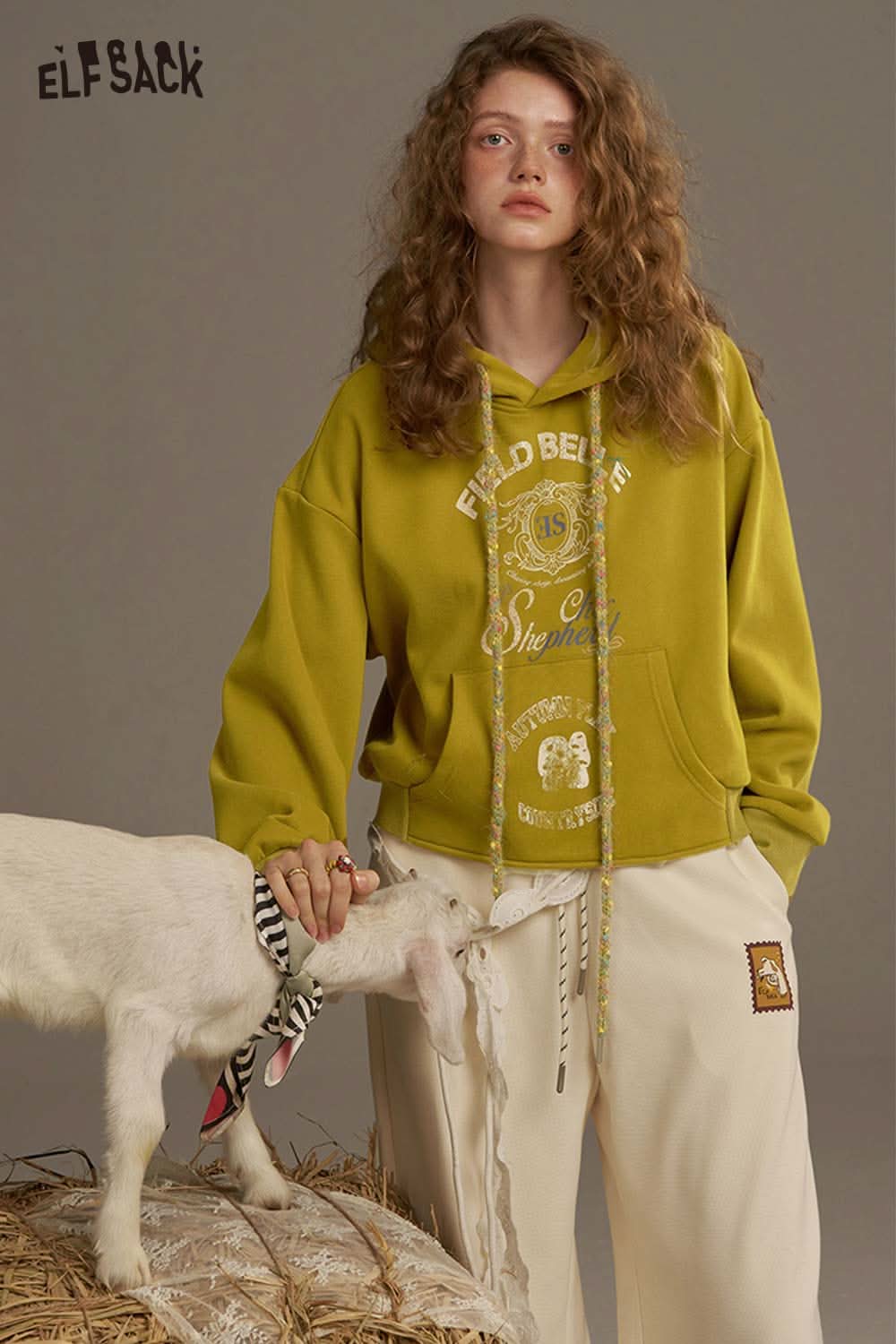 ELFSACK women's oversized print hoodie in olive green with graphic design, styled with casual pants