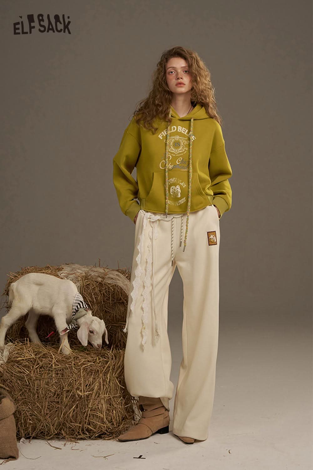 ELFSACK women's oversized print hoodie in mustard yellow, styled with wide-leg cream pants and a cute goat