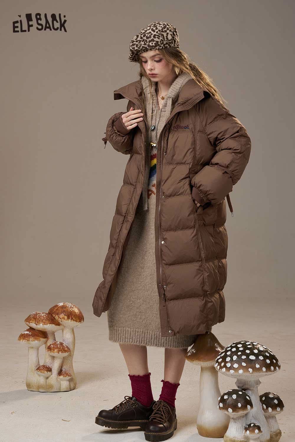 ELFSACK women's pink long down coat shown in a stylish setting with mushrooms