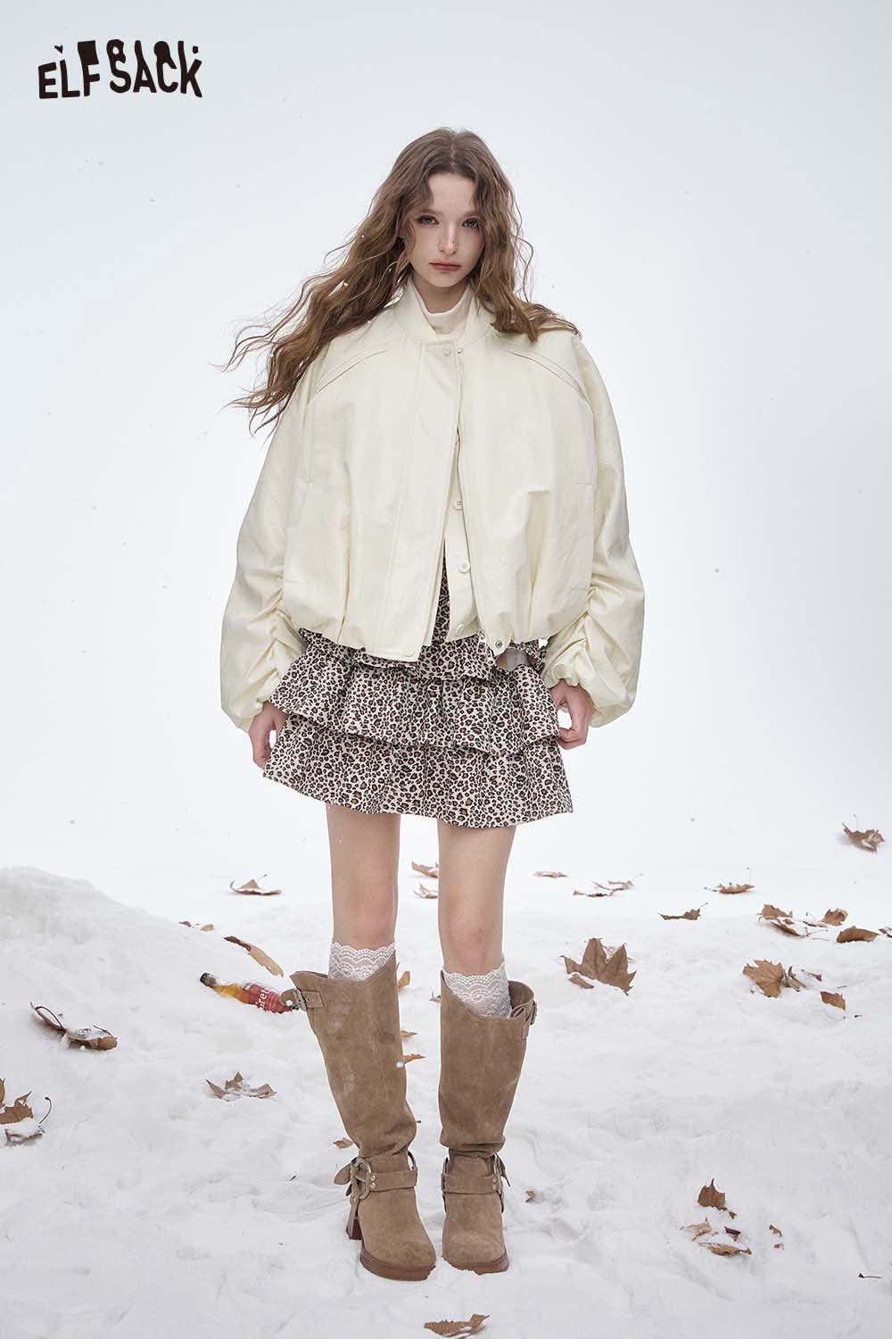 ELFSACK women's puff sleeve down jacket styled with a trendy skirt and winter boots in a snowy setting