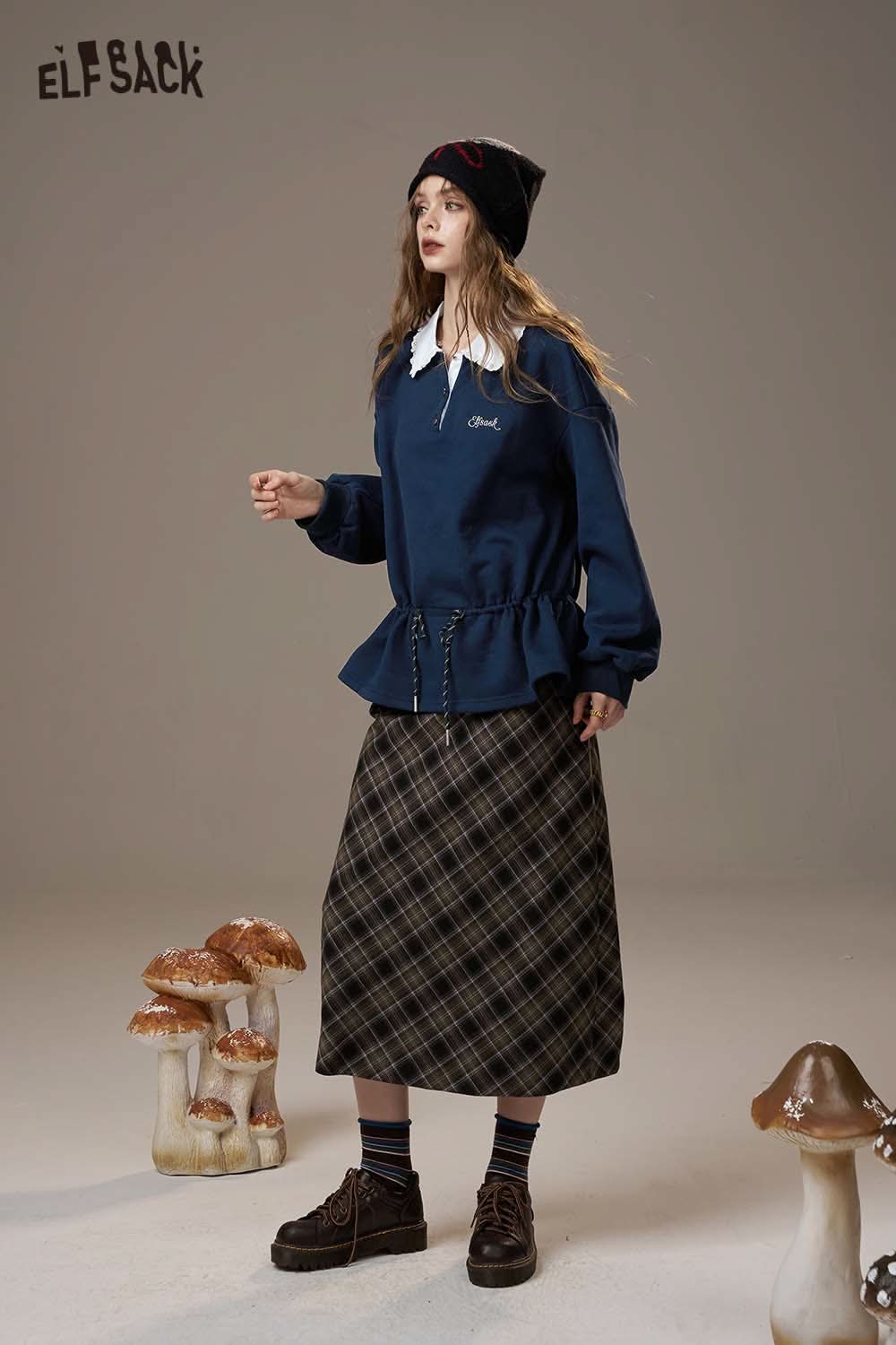 ELFSACK women's soft pullover top in navy, styled with a pleated hem and layered over a plaid skirt
