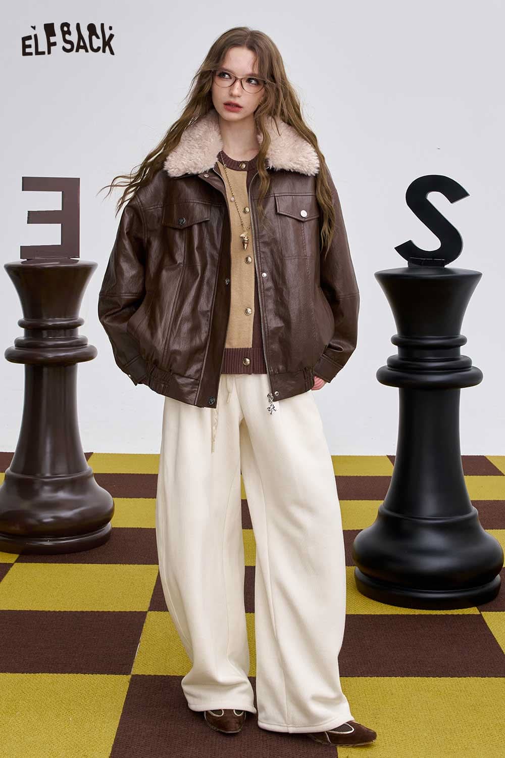 Stylish women's soft round neck sweater layered under a brown leather jacket for a cozy look