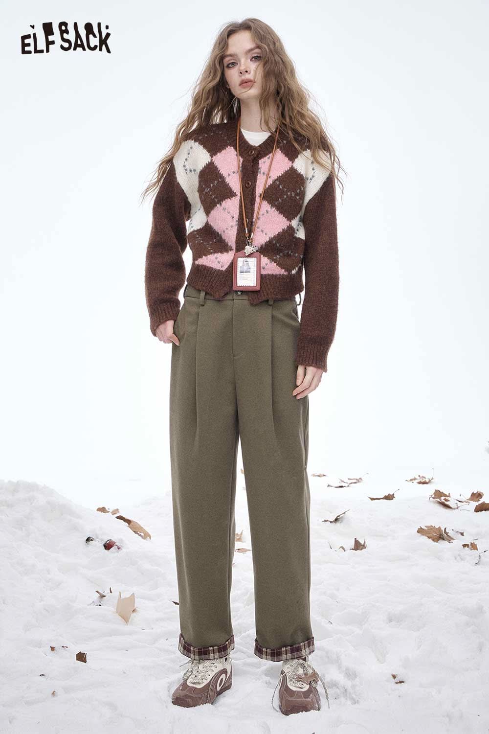 Model wearing ELFSACK women's striped cuff straight pants styled with a colorful sweater in a snowy setting