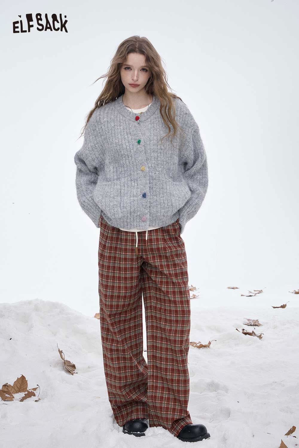ELFSACK women's striped floor length pants paired with a cozy knit sweater on a snowy background