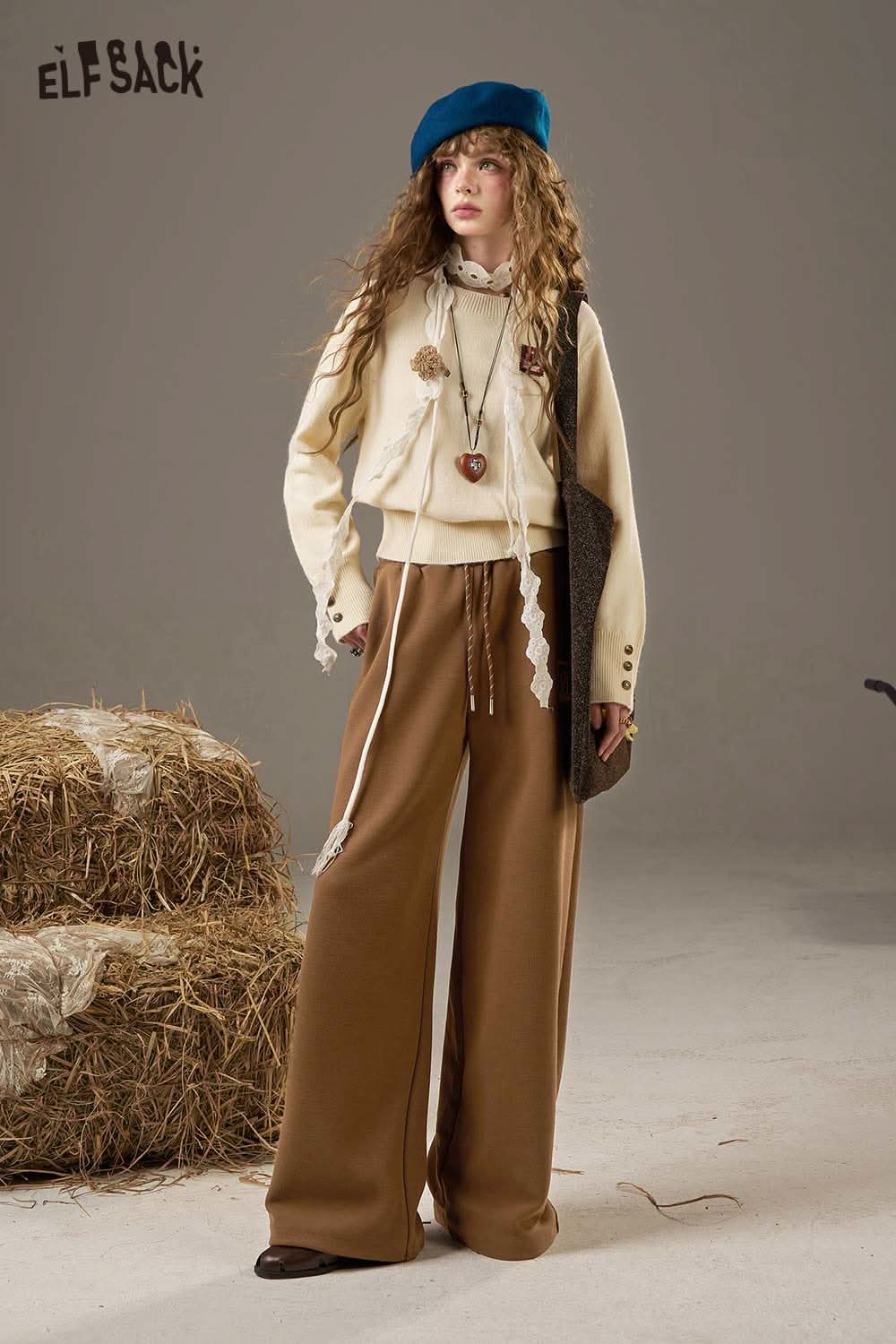 Brown women's wide leg sweatpants by ELFSACK styled with a casual top and accessories in a rustic setting
