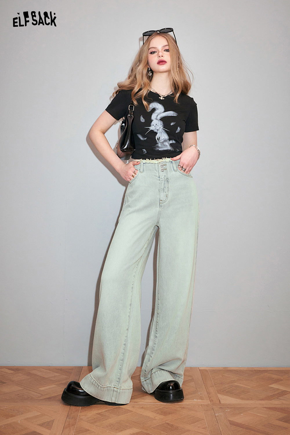 ELFSACK black Y2K Rabbit Print t-shirt worn by model with light washed wide-leg jeans and black shoes