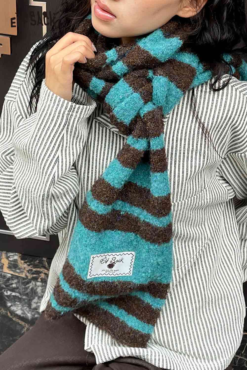 ELFSACK Y2K stripe neck warmer in teal and brown, worn stylishly for warmth and fashion