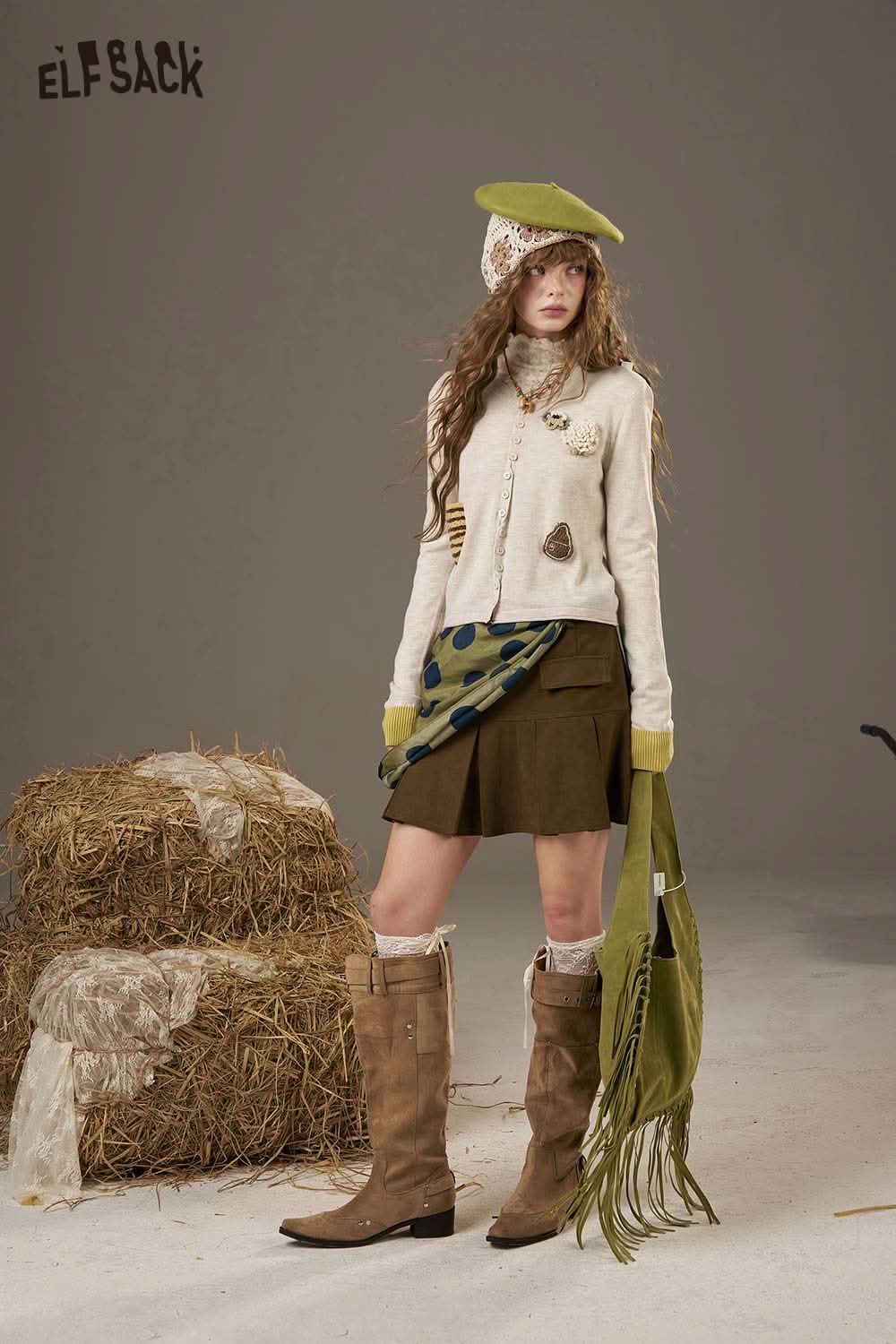 ELFSACK zebra print knit sweater for women styled with a skirt and boots in a rustic setting