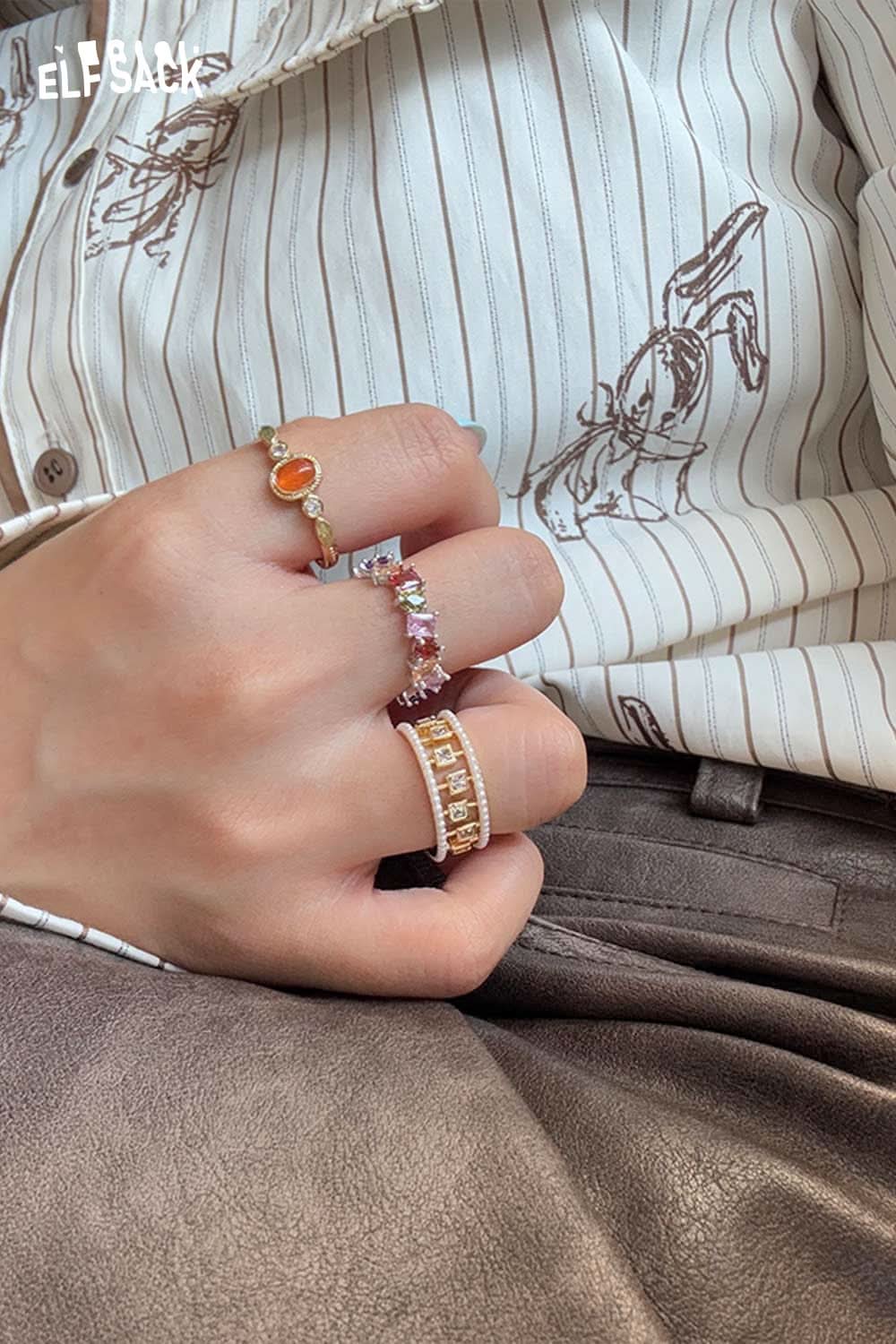 ELFSACK zirconia gemstone copper ring displayed among stylish hand jewelry in a fashion setting