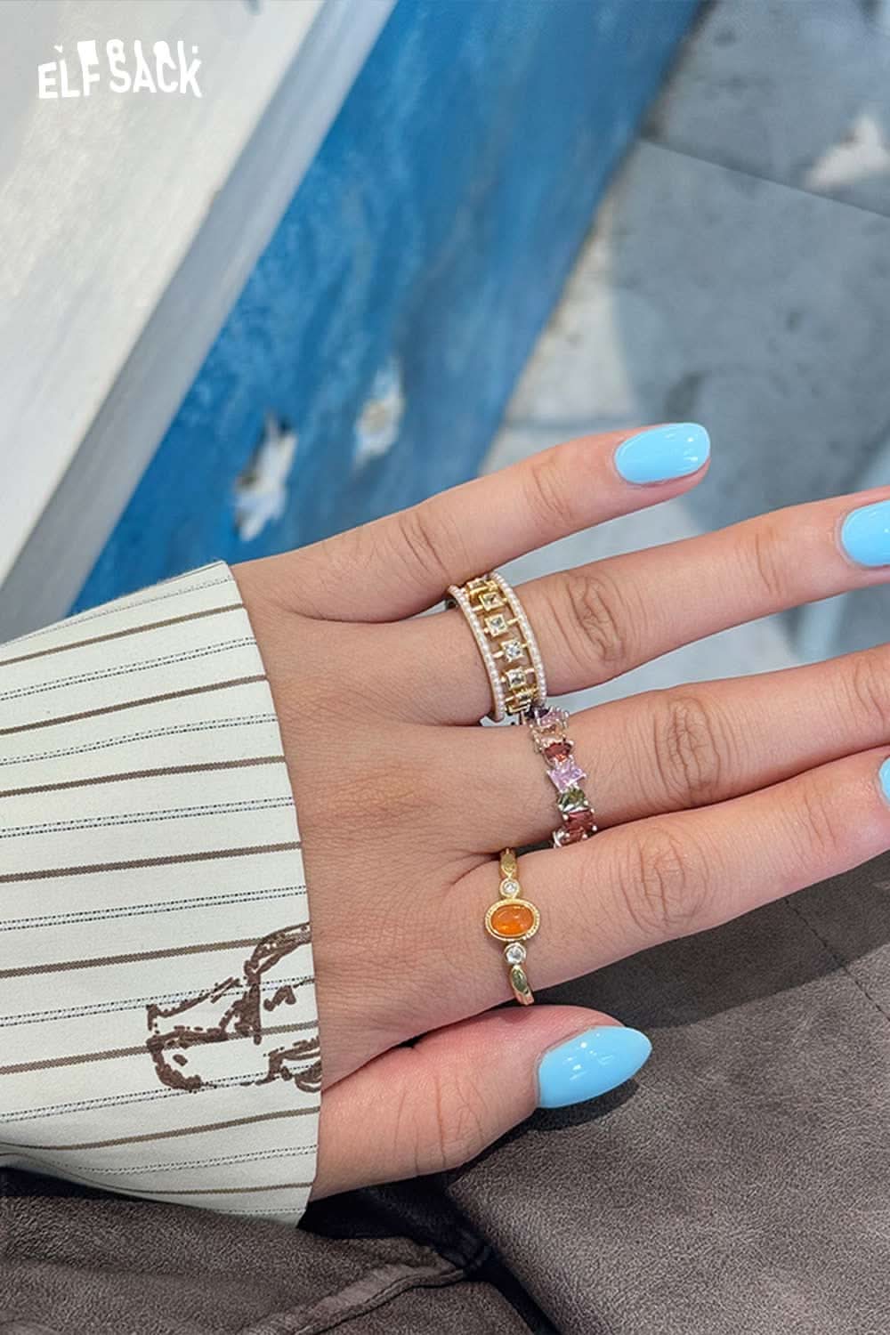 ELFSACK zirconia gemstone copper ring showcased on hand with colorful nail polish